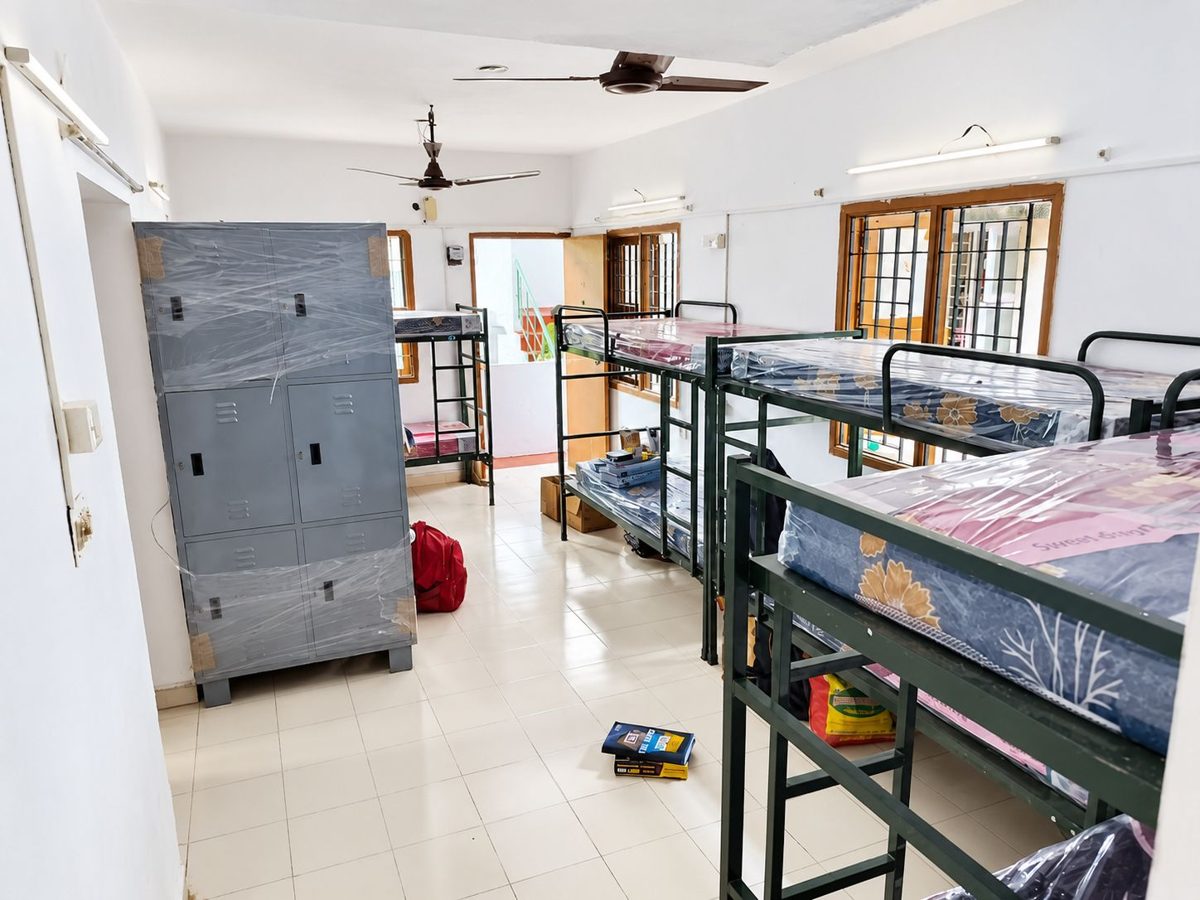 Large room with several bunk beds, two ceiling fans and a grey metal locker