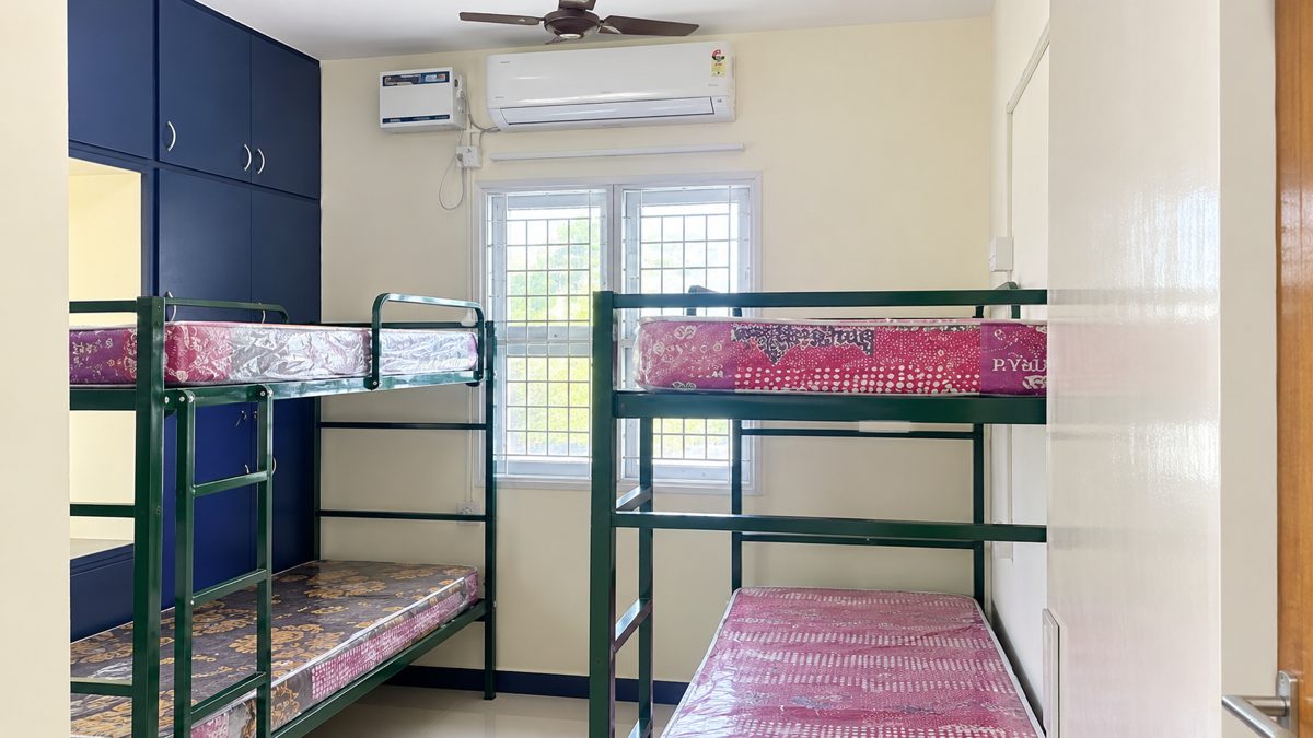Shared room with two bunk beds, blue built-in cabinets, an air conditioner, ceiling fan and window